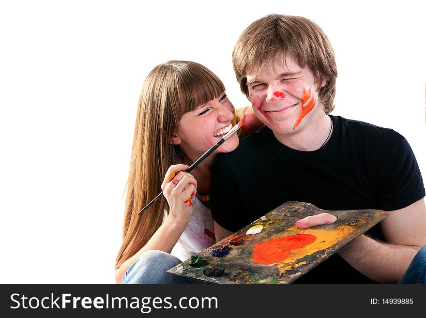 Young couple playing with painting on painted background.