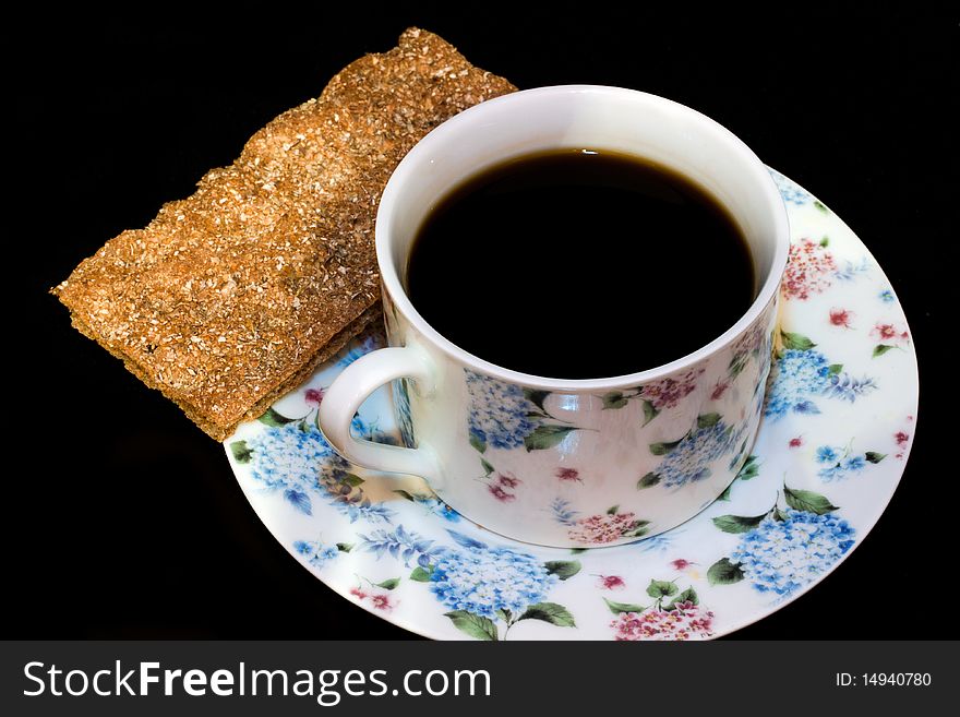 A cup of coffee and a bread crisp. A cup of coffee and a bread crisp