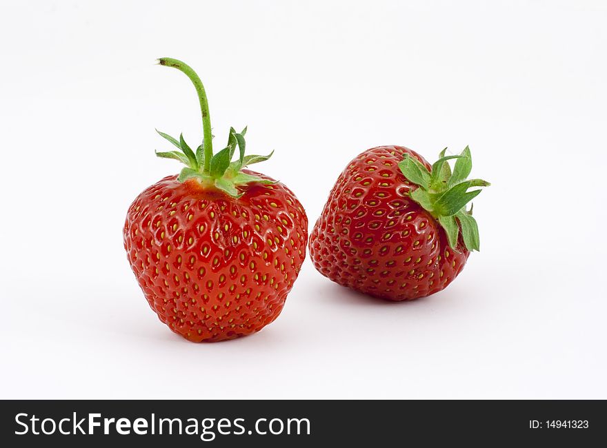 Two isolated strawberries on white. One upright the other at an angle. Two isolated strawberries on white. One upright the other at an angle.