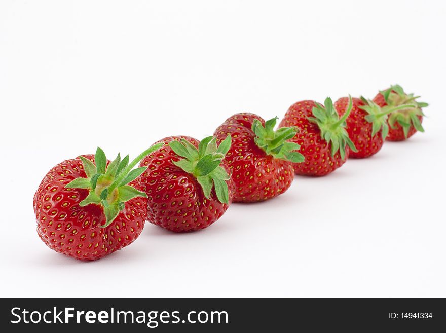 Six ripe, freshly picked strawberries in a row with narrow depth of field. Six ripe, freshly picked strawberries in a row with narrow depth of field.