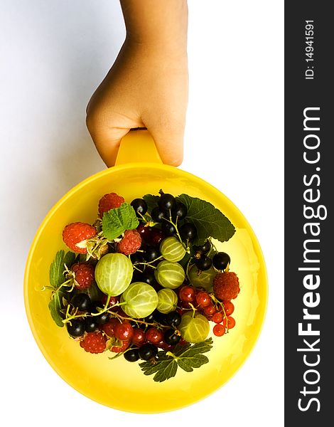 A photo of a child's hand offering some berries in a cup. A photo of a child's hand offering some berries in a cup