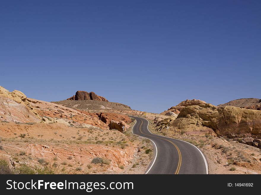 Winding desert road along red rocks