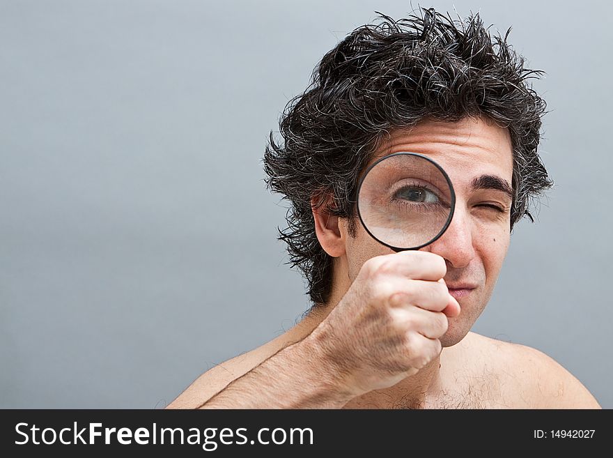 Curious man holding a magnifier over his eye. Curious man holding a magnifier over his eye