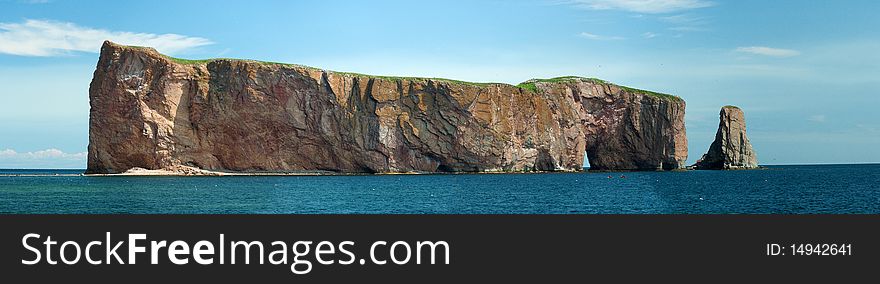 The Rocher Percé, a holed rock near the coast in eastern quebec. The Rocher Percé, a holed rock near the coast in eastern quebec