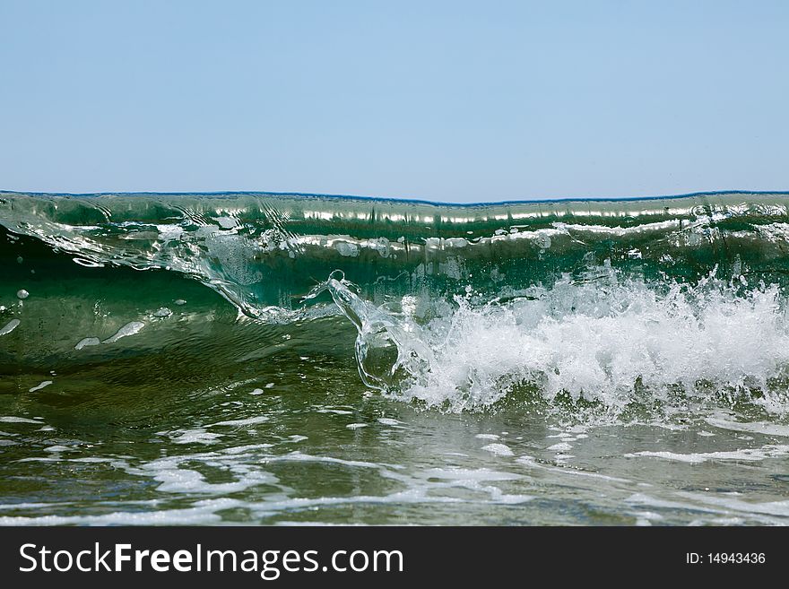Green sea wave disperses the foam. Green sea wave disperses the foam