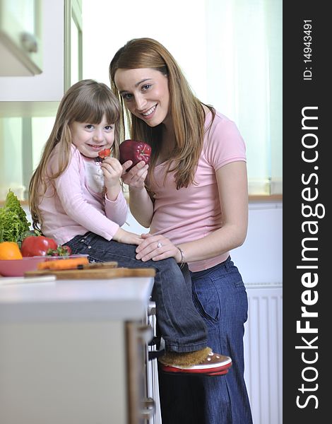 Happy young family have lunch time with fresh fruits and vegetable food in bright kitchen. Happy young family have lunch time with fresh fruits and vegetable food in bright kitchen