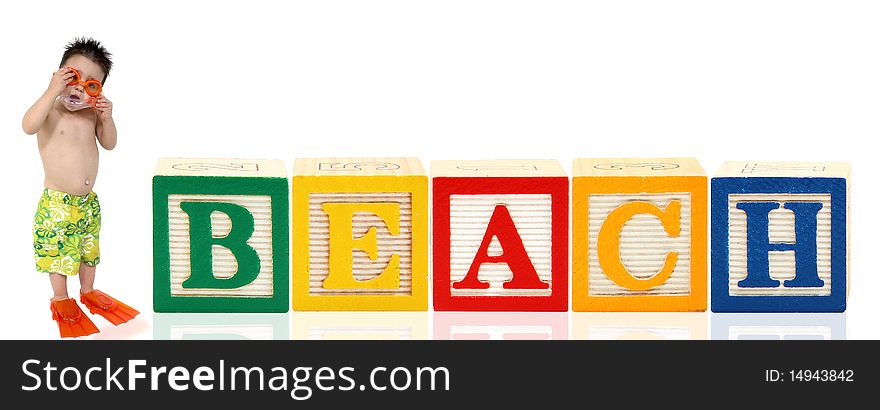 Colorful alphabet blocks. spelling the word beach. Adorable three year old boy in swimsuilt standing beside it. Colorful alphabet blocks. spelling the word beach. Adorable three year old boy in swimsuilt standing beside it.