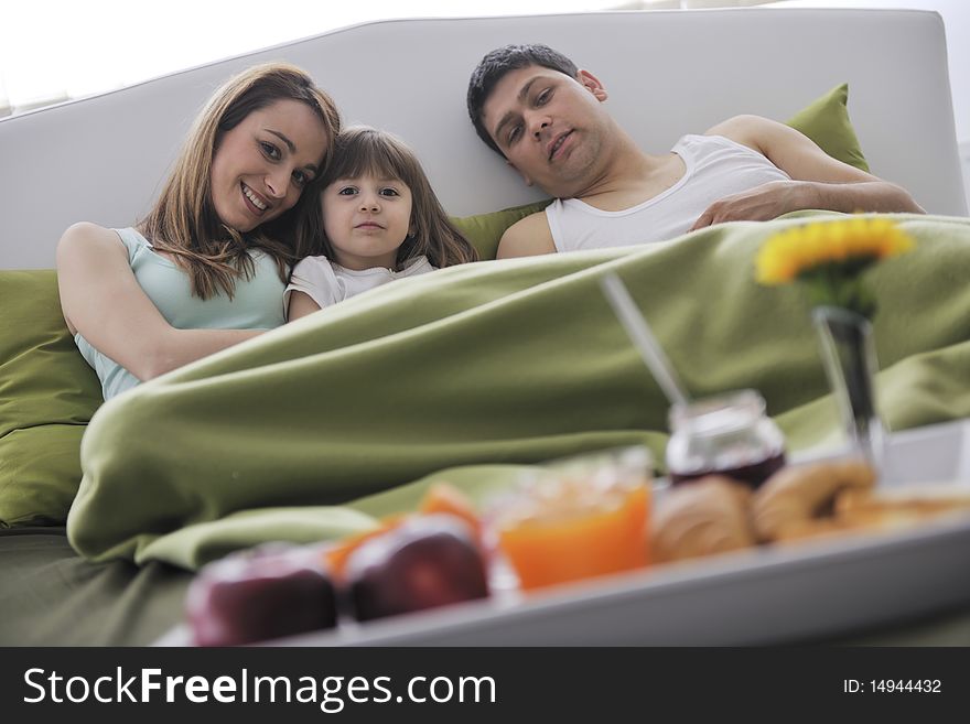 Happy Young Family Eat Breakfast In Bed