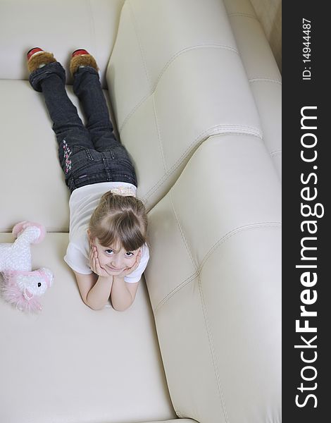 Happy cute little girl relax  on sofa at home