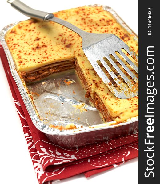 A tray of lasagne isolated against a white background