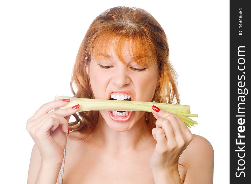 A redhead young woman biting a fresh green celery. A redhead young woman biting a fresh green celery