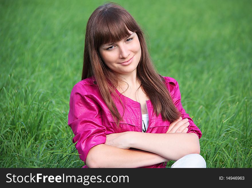 Smiling girl sitting in the grass
