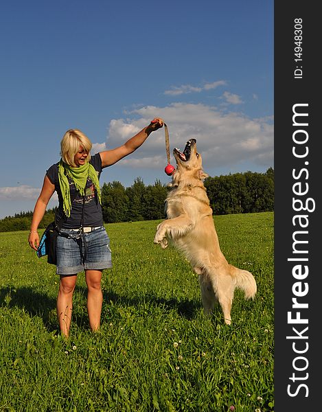 Happy young woman playing with her golden retriever. Happy young woman playing with her golden retriever