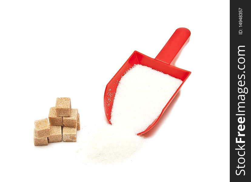 Red scoop of the sugar spilling on white surface.