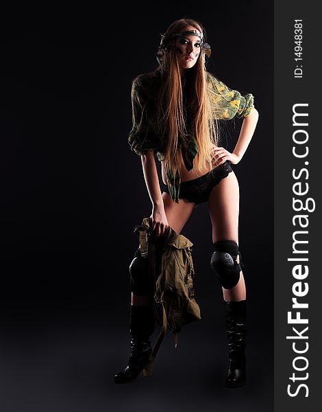 Shot of a sexy woman in military uniform posing against black background. Shot of a sexy woman in military uniform posing against black background.