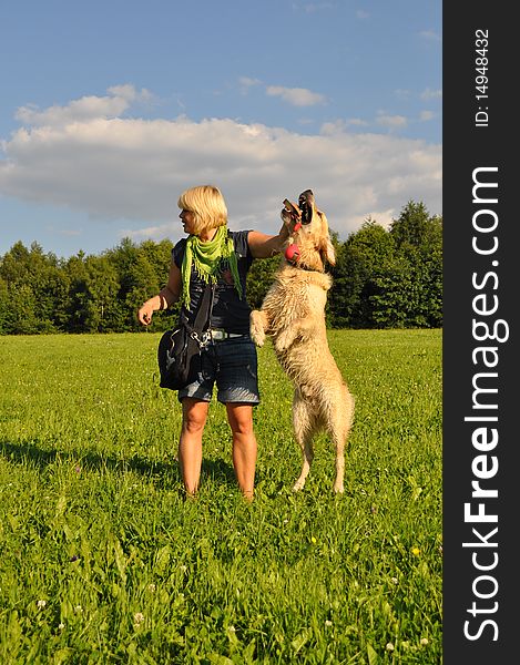 Happy young woman playing with her golden retriever. Happy young woman playing with her golden retriever
