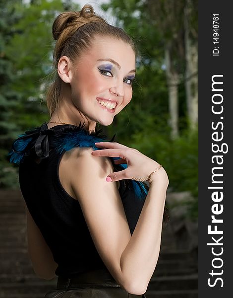 Girl in blouse with peacock feathers posing