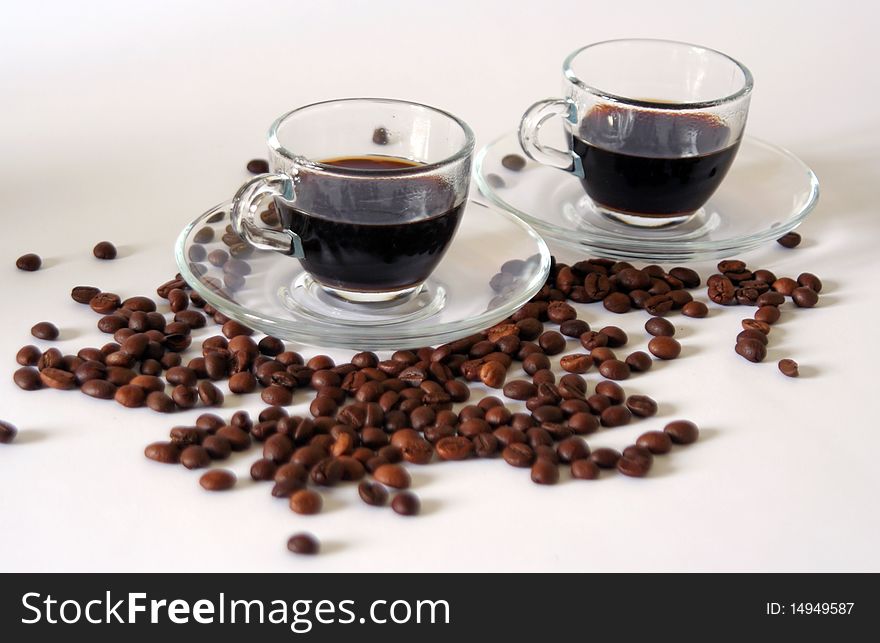 Two coffee cups and coffee beans on white background, still-life. Two coffee cups and coffee beans on white background, still-life