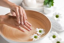 Woman Soaking Her Hands In Bowl Of Water And Flowers On Table, Closeup. Spa Treatment Stock Image Woman Soaking Her Hands In Bowl Of Water And Flowers On Table, Closeup. Spa Treatment Stock Image