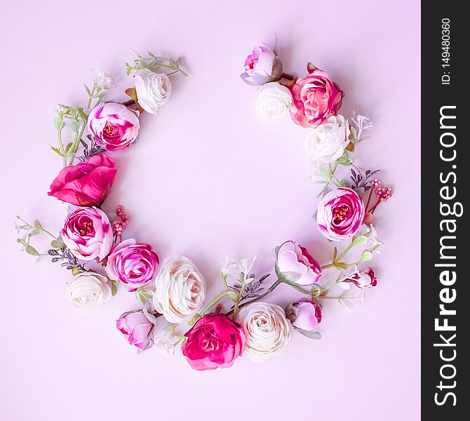 Spring wreath made of colorful flowers on pink  background, place for text, holiday concept. Flat lay. Spring wreath made of colorful flowers on pink  background, place for text, holiday concept. Flat lay.