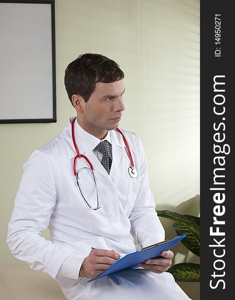 Male doctor with paperwork in her office