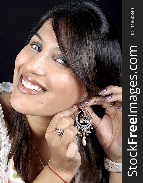 Indian female girl showing antique ear-ring.