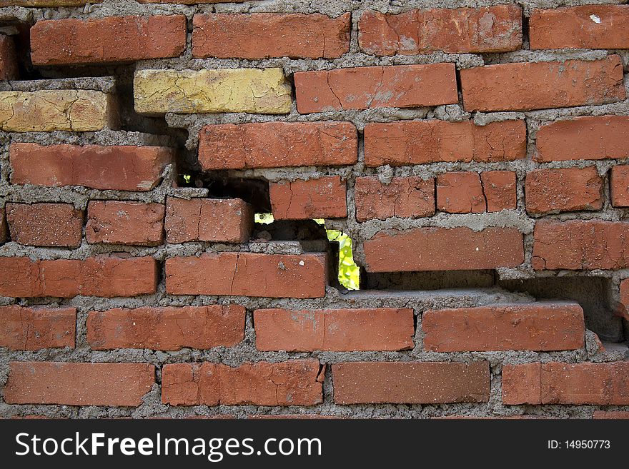 The big crack and hole in a wall a construction from a brick. The big crack and hole in a wall a construction from a brick