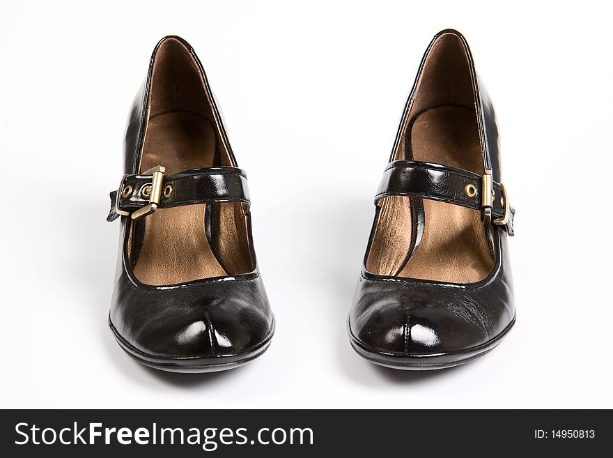 The female black varnished shoes on a white background. The female black varnished shoes on a white background