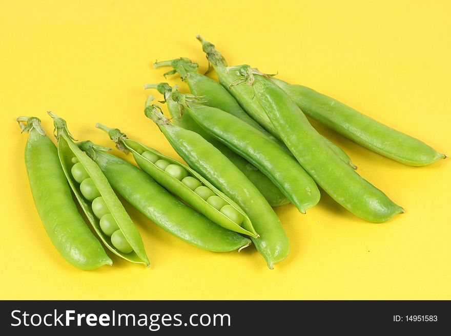 Green peas isolated on the Yellow background