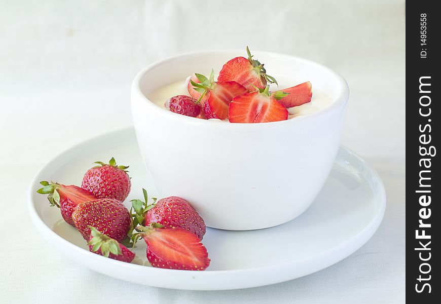 Yogurt with strawberries for breakfast in white bowl