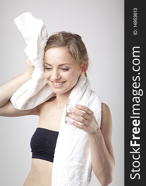 Woman Drinking Water wearing sportswear and towel. Woman Drinking Water wearing sportswear and towel