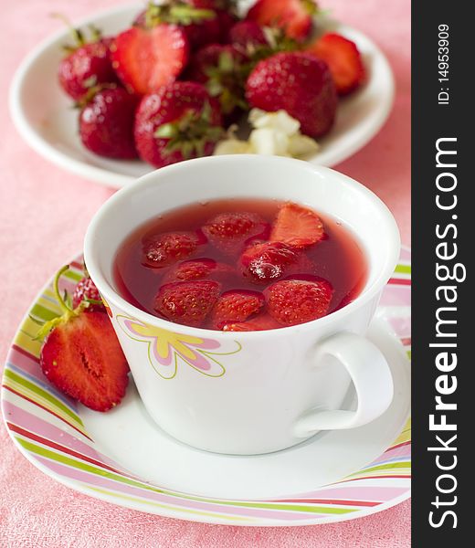 Strawberry tea in a white mug with fresh strawberry. Strawberry tea in a white mug with fresh strawberry
