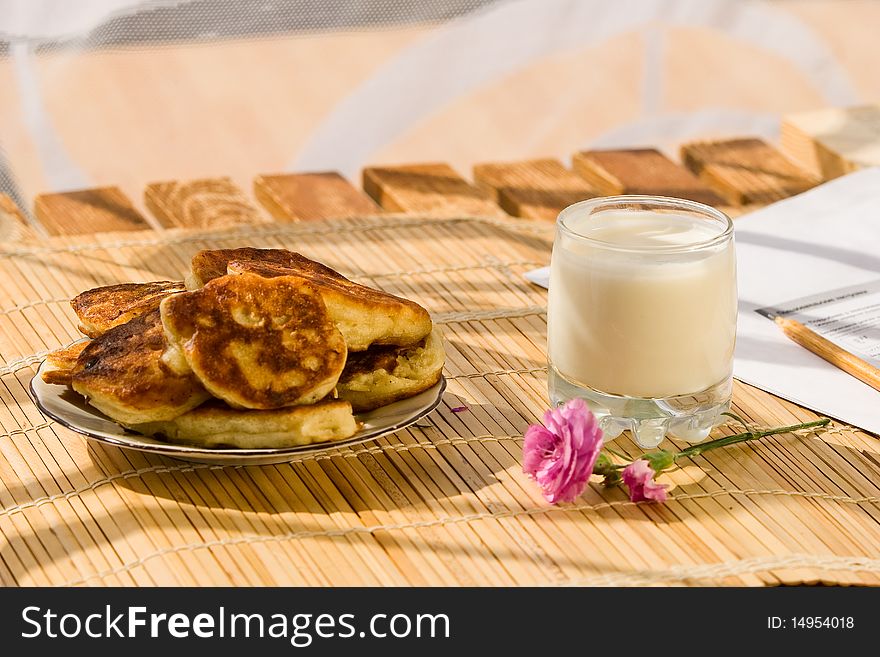 Breakfast in summer day in village: pancakes with milk