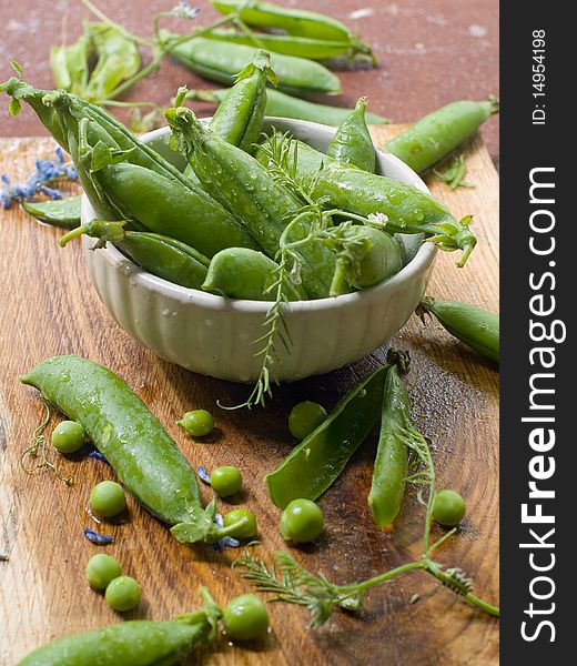 Freshly picked sweet garden peas in a bowl sitting on a table. Freshly picked sweet garden peas in a bowl sitting on a table