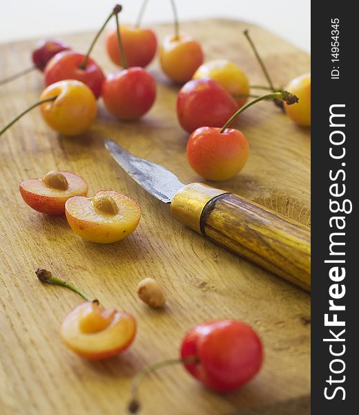 Whole and half cherries on wood board