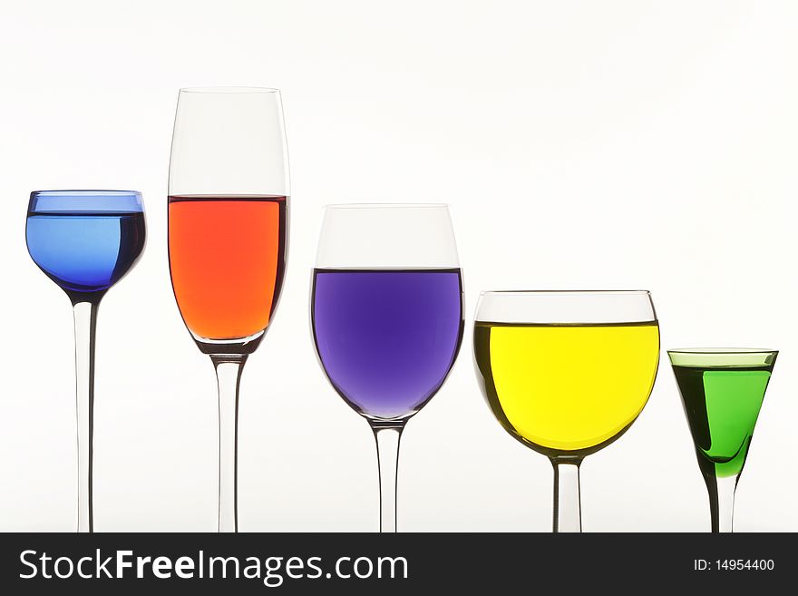 Five multi-coloured wine-glasses on white background