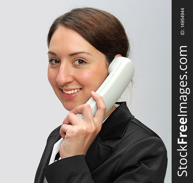 Young woman talking by the phone . Office secretary