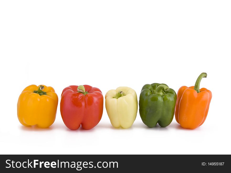 Five different coloured peppers in a row isolated on white. Five different coloured peppers in a row isolated on white