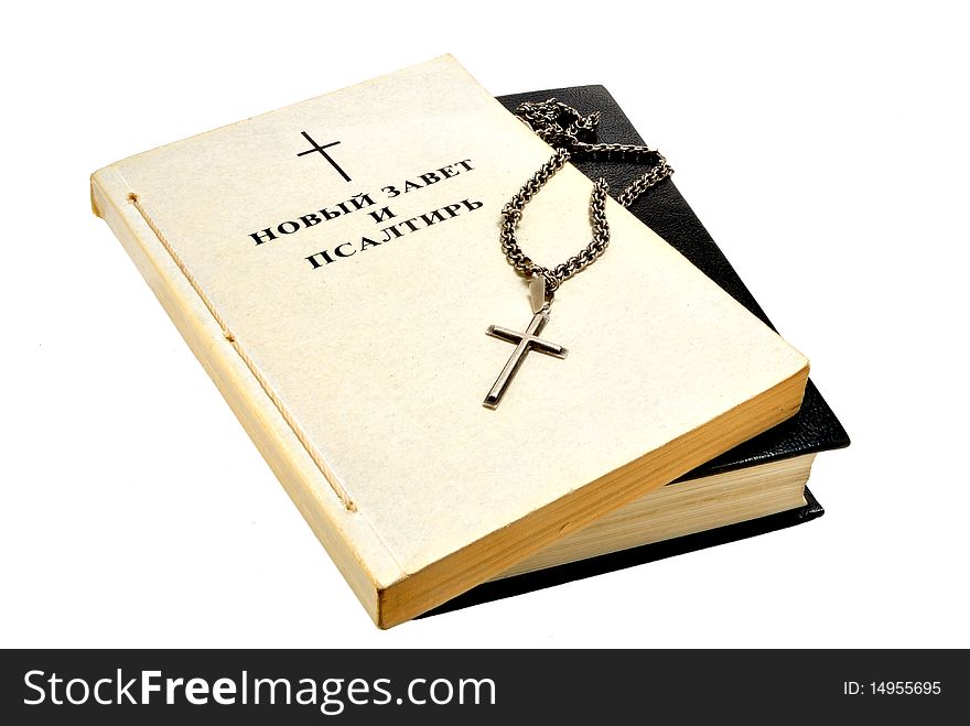 Book of the Bible and a silver cross and chain on white background