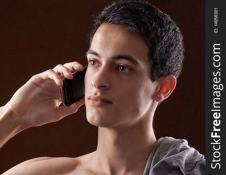 A simple portrait of a handsome young man talking on a cell phone. A simple portrait of a handsome young man talking on a cell phone