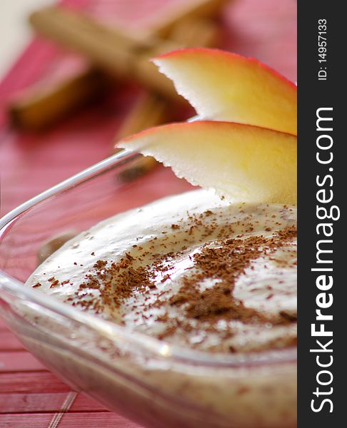 Pudding with apple and nut in ice glass and red background