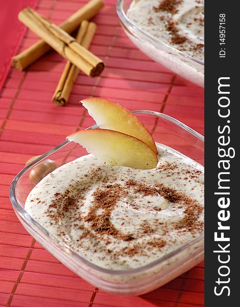 Pudding with apple and nut in ice glass and red background