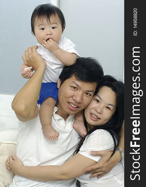 Asian family smiling together in living room