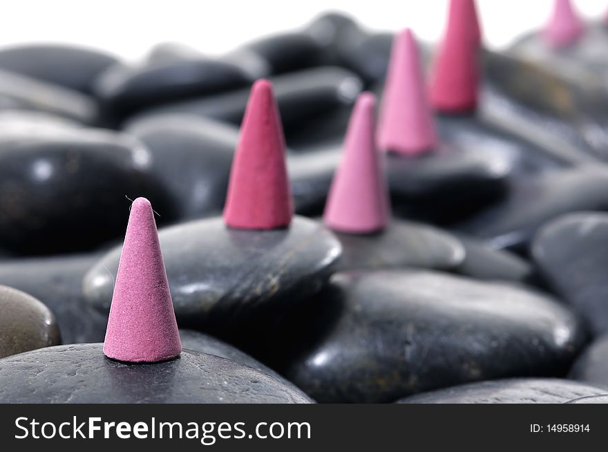 A row of incense cones on pebbles