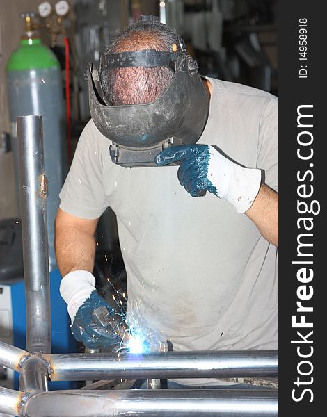 A man welding in a workshop. A man welding in a workshop