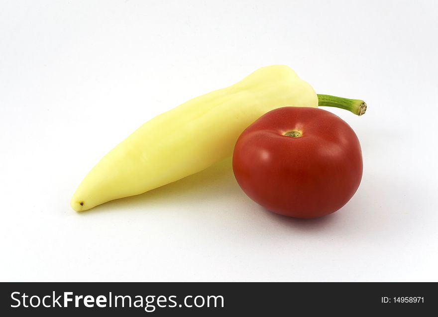 Yellow pepper and tomato on white