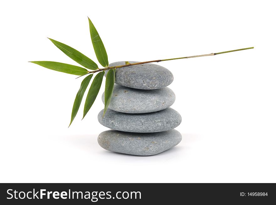 Balanced stones with bamboo leaf on white. Balanced stones with bamboo leaf on white