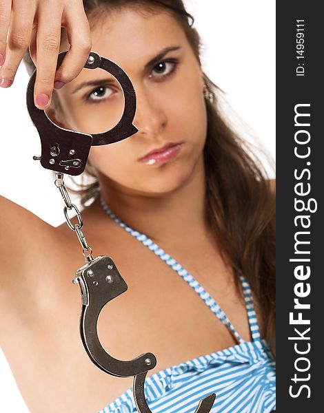 Pritty brunet looking through handcuffs isolated on white