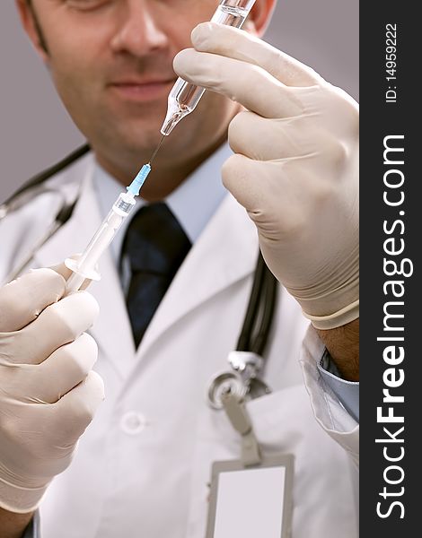 Professional doctor with medical syringe in hands, getting ready for injection