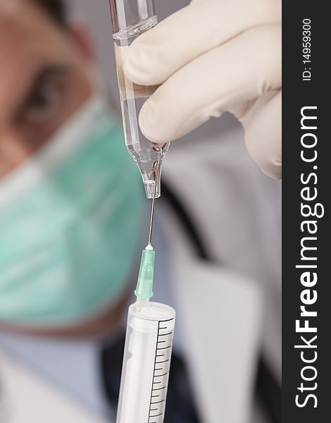 Professional doctor with medical syringe in hands, getting ready for injection